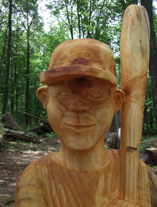 wood sculpture of boy baseball player
