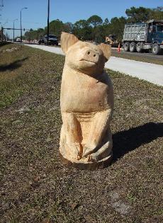 Sitting Pig chainsaw carving
